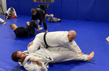 Adults practicing Brazilian Jiu-Jitsu in a dojo, showcasing training and techniques in adult Brazilian Jiu-Jitsu classes.