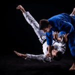 Judo athletes demonstrate a throw, showing the physical and mental benefits of judo training.