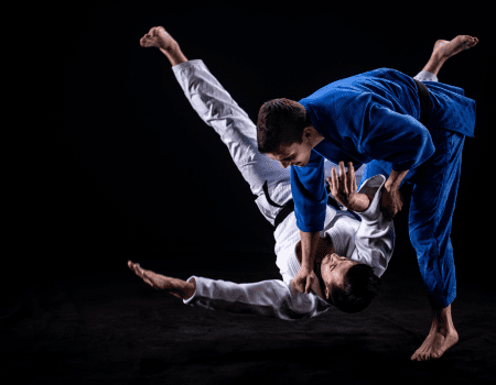 Judo athletes demonstrate a throw, showing the physical and mental benefits of judo training.