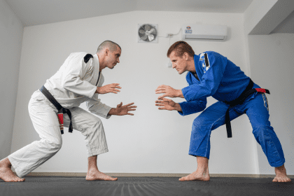 Two BJJ practitioners in a standing face-off, demonstrating ready stances and BJJ positions during training.