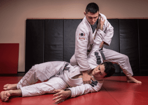 BJJ practitioner applying a strong top control technique on an opponent, demonstrating dominance and technique in training.