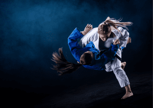 Two judo practitioners in action, one performing a dynamic throw on the other during an intense training session.