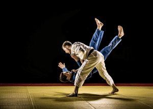 Two judo practitioners performing a dynamic throw on the mat, showcasing technique and skill in mid-air action.