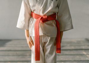 A child wearing a orange belt and gi, representing an advanced stage in the judo belt system and martial arts training.