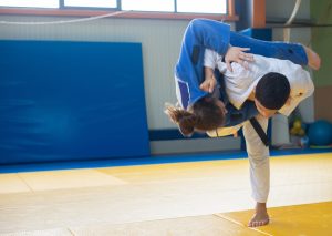 Judo vs Jiu-Jitsu: Practitioners in gis demonstrate a powerful throw technique during martial arts training.