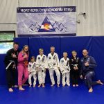 Group photo of a jiu-jitsu class at Northern Colorado Jiu Jitsu, featuring kids and instructors in uniforms.