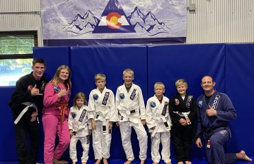 Group photo of a jiu-jitsu class at Northern Colorado Jiu Jitsu, featuring kids and instructors in uniforms.